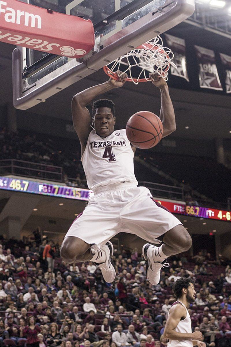 Sophomore forward Tavario Miller hangs on the rim after a dunk during the 109-68 season-opening victory against Northwestern State at Reed Arena.