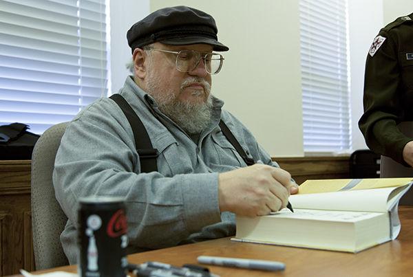 File
George R.R. Martin signs books during a visit to campus in 2013. 
 