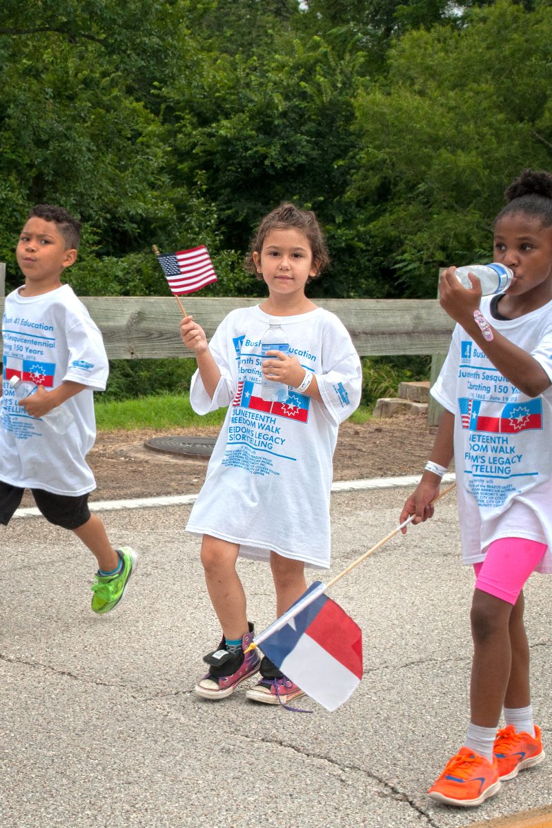 Many+children+proudly+waved+their+Texan+and+American+flags+during+the+Juneteenth+Freedom+Walk.