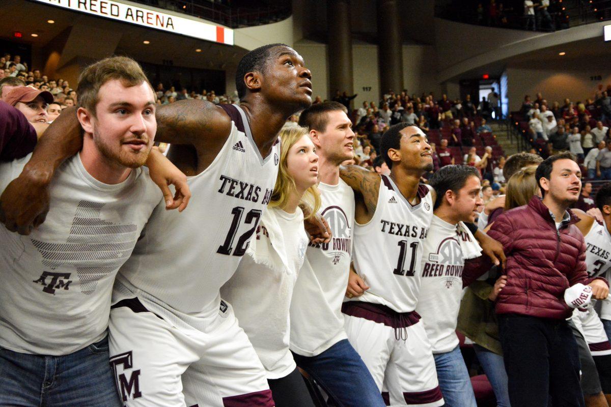 Jalen Jones and Anthony Collins sing the Aggie War Hymn with the crowd after earning the win over Iowa State.
