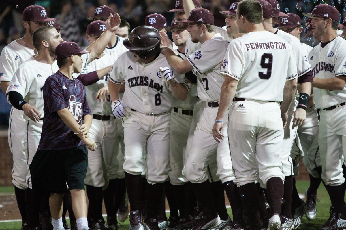 The Aggies celebrate with their teammate Boomer White after he hit a home run.