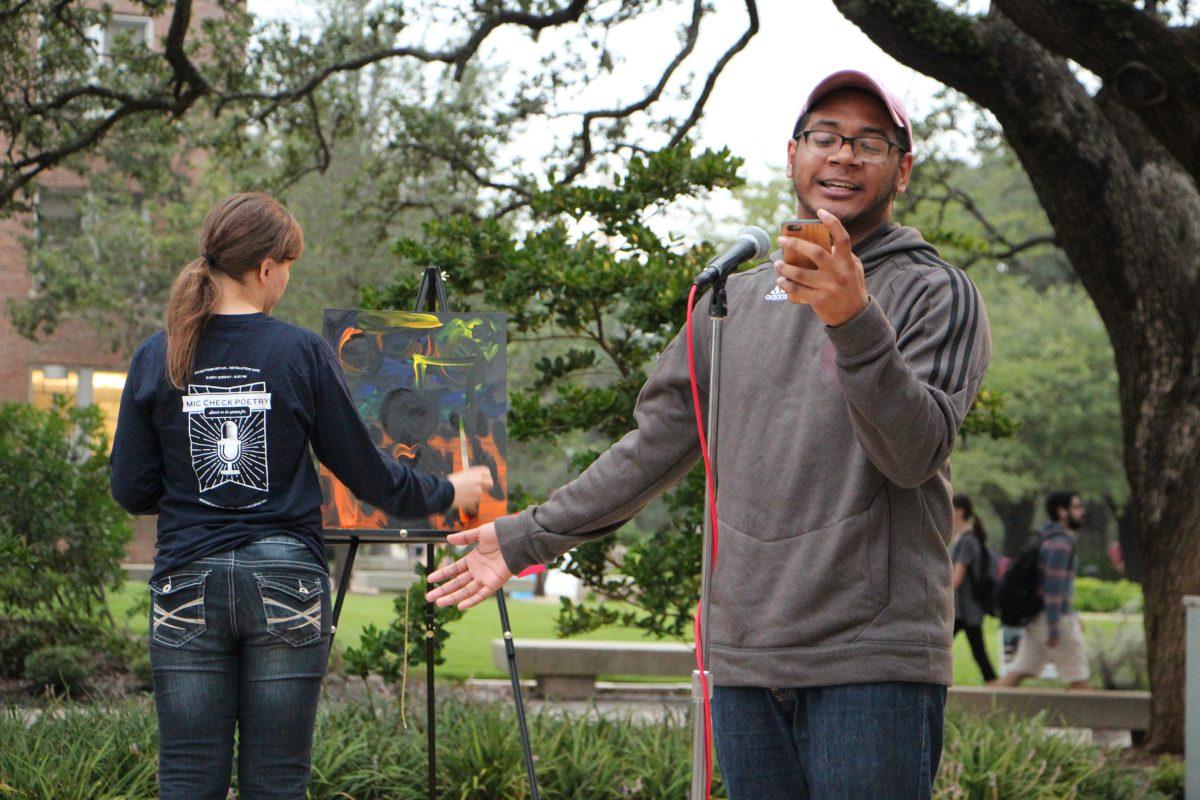 Senior english major Lino Anunciacion shares a poem while local artist Lisa Urban simultaneously paints at the "Love Your Melanin" event hosted by MSC WBAC. Anunciacion's poem was centered around defying the stereotype that black men can't be emotional.