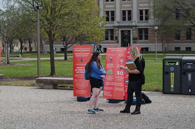 Jillian Ferguson (right), southwest regional coordinator for Students for Life of America, discusses Federally Qualified Health Centers with a student as part of her organization's demonstration.