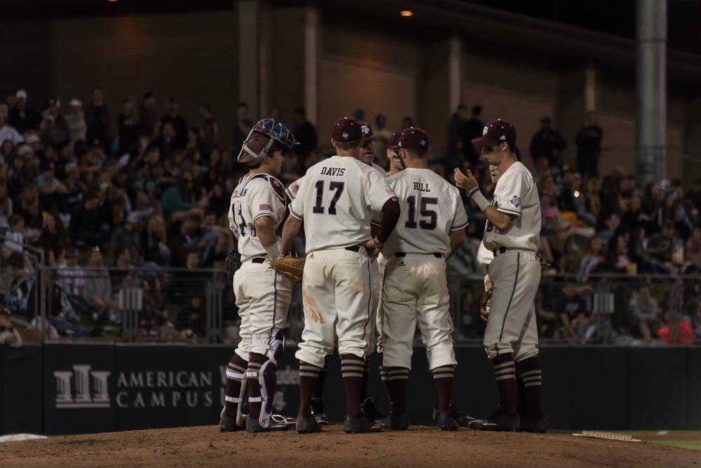 The Aggies meet on the mound to discuss strategy.