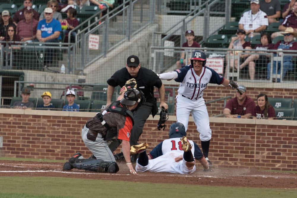 Senior Nick Choruby slides into home plate while the umpire pauses before calling him safe against Bowling Green. Teammate Joel Davis is already doing that. 