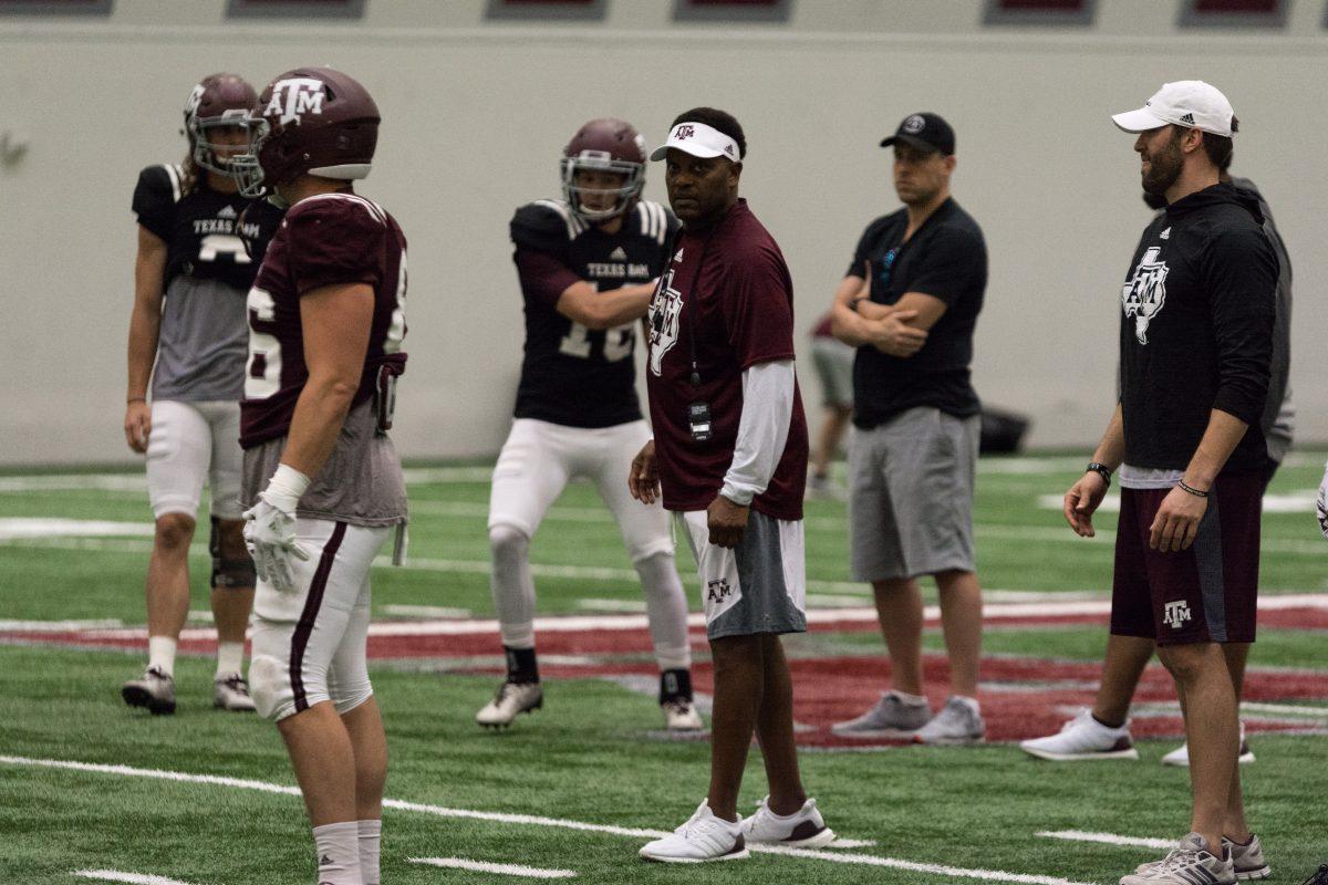 Head Coach Kevin Sumlin coaches his quarterbacks and wide receivers during a drill. 