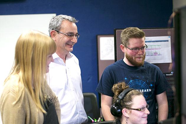 3D Artist Rebecca Migl, Andre Thomas, programmer Chase Hardy and Elizabeth Stephens gather around Stephens&#8217; computer to discuss Variant and 3D environments.