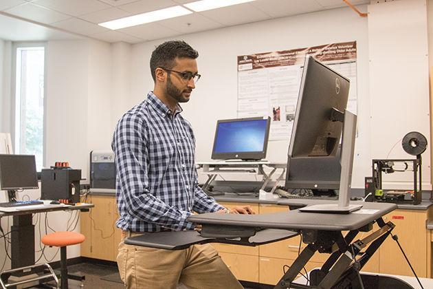 Prag Sharma, Doctoral Student, demonstrates use of a standing desk which is being used as part of his research into ergonomics.