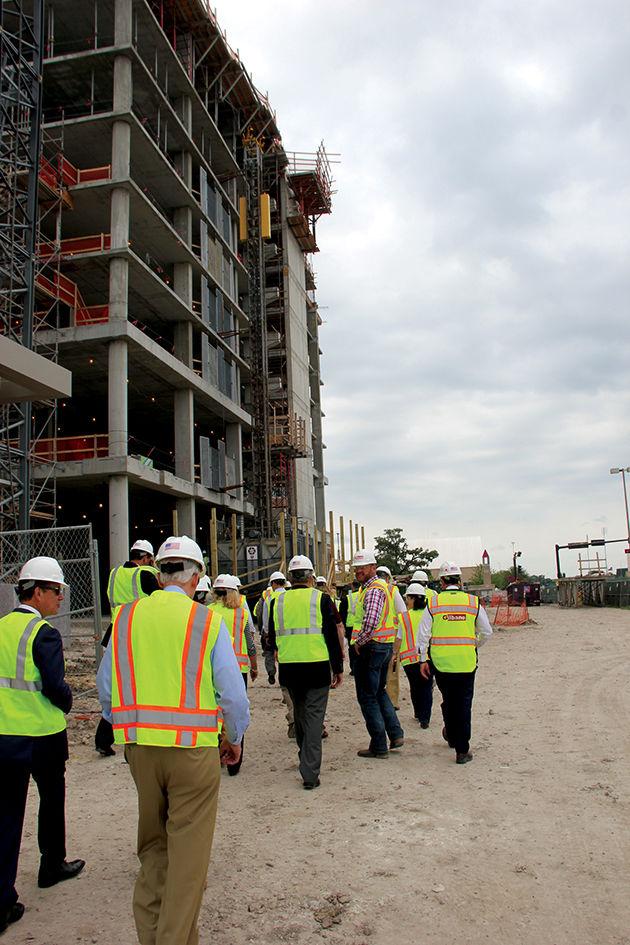 Workers+walk+to+the+construction+site+of+the+hotel.+Construction+is+expected+to+be+completed+before+the+2018+football+season.