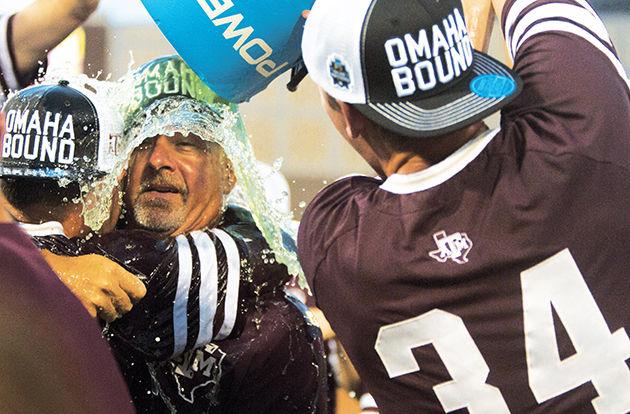 Mitchell Kilkenny dumps an ice bucket of Powerade on A&amp;M head coach Rob Childress and Joel Davis in celebration of the Super Regional win.