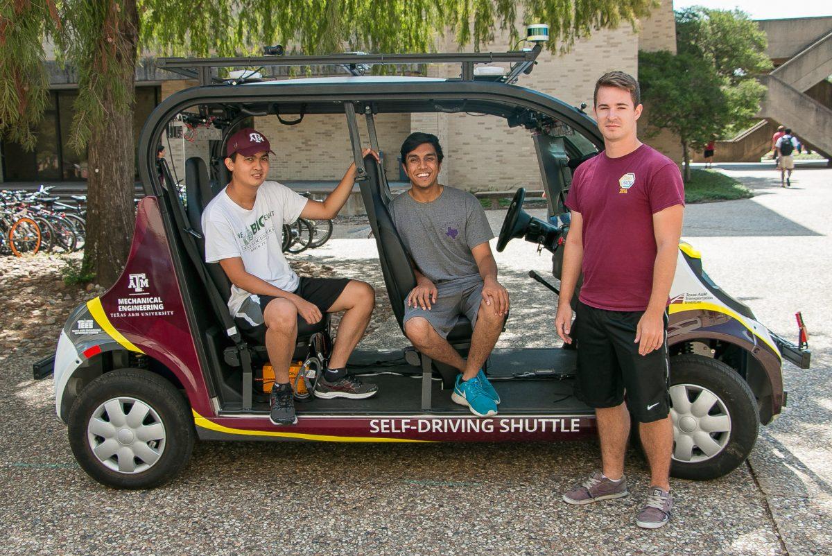 Ph.D. candidate Garrison Neel (right) and mechanical engineering seniors Amir Darwesh (center) and Quang Le (left) work together to build the first autonomous shuttle.