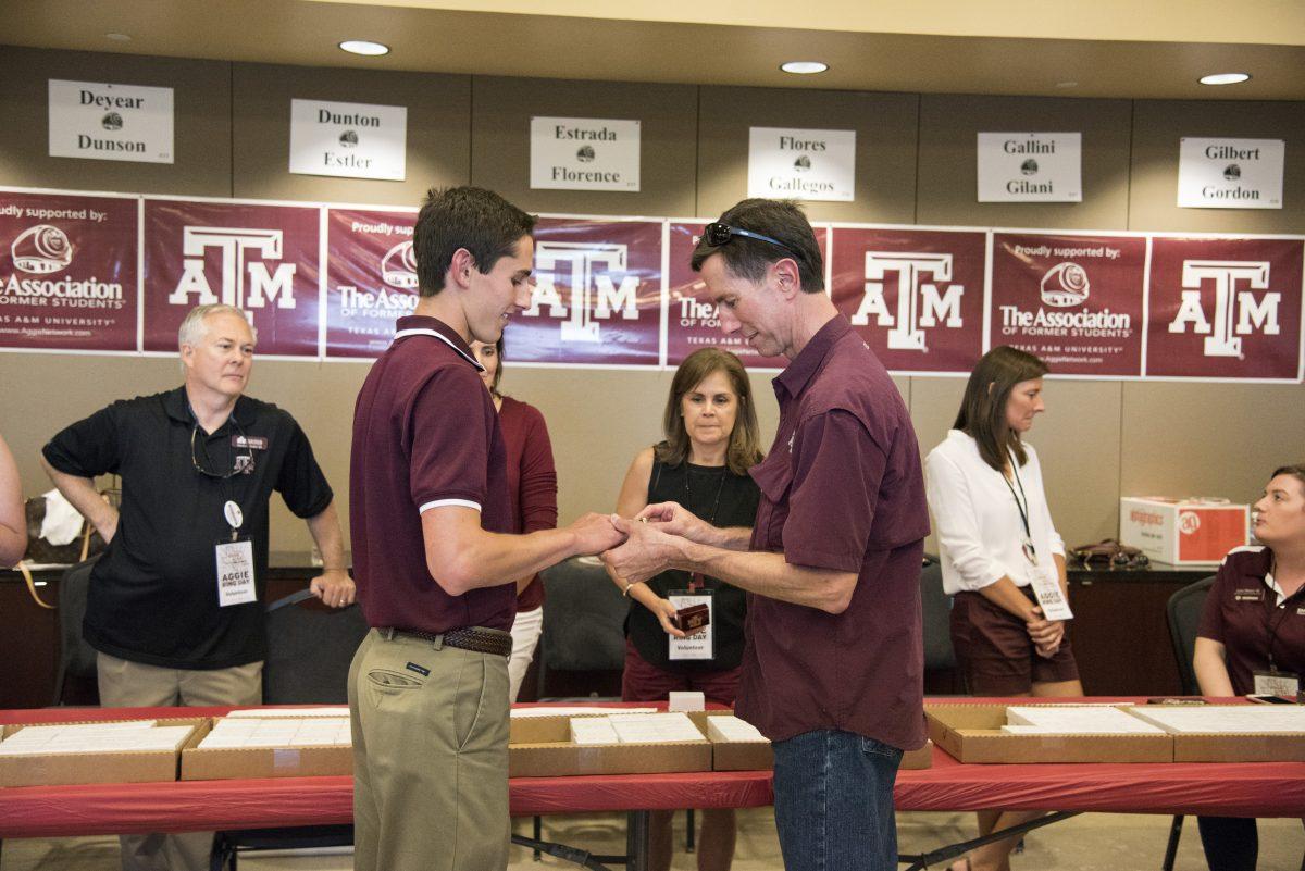 Jeff Fattig places his son, computer engineering senior Shaun Fattigs Aggie Ring on his finger for the first time.
