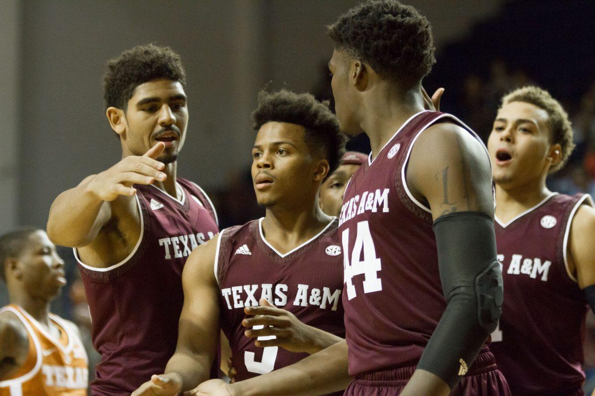 (left to right) Juniors Tyler Davis and Admon Gilder celebrate with sophomore Robert Williams after a play during A&M’s exhibition game against Texas Oct. 25 in Houston. The game was held to raise money for Rebuild Texas, which benefits hurricane relief efforts. 