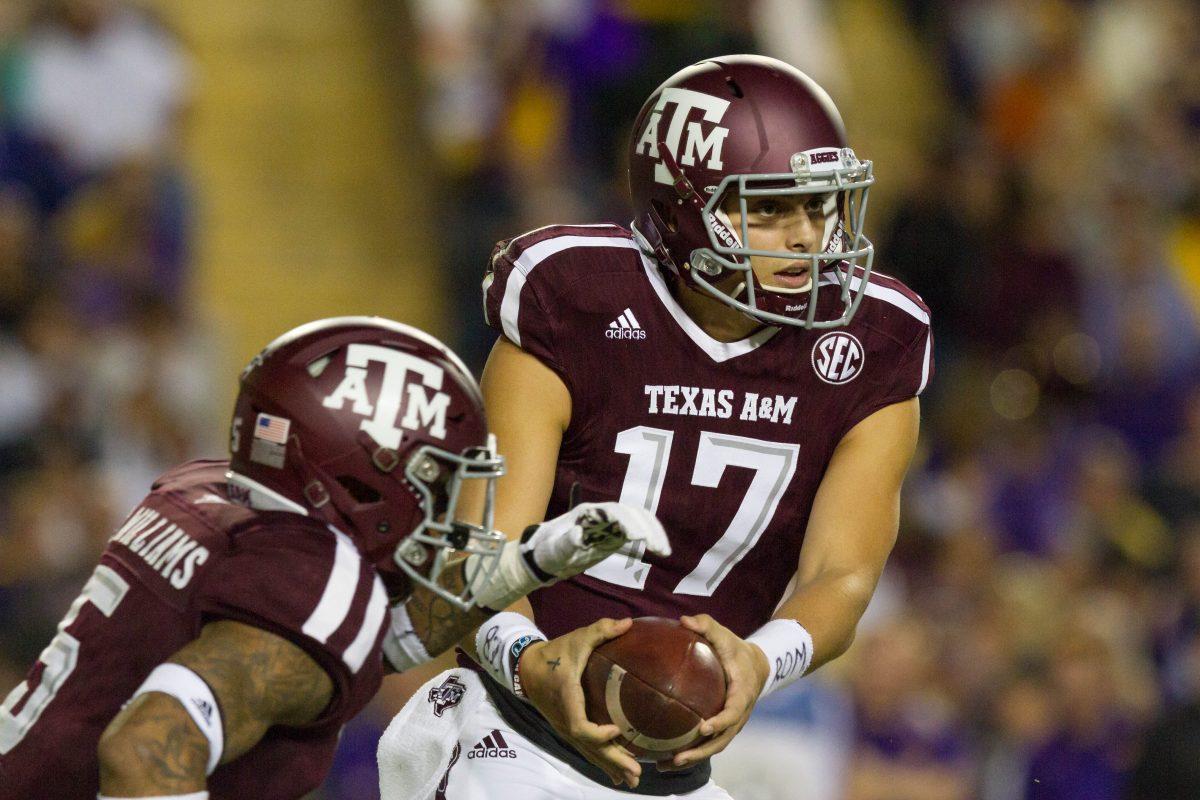 Redshirt freshman quarterback Nick Starkel hands the ball of to sophomore running back Trayveon Williams during the game against LSU on November 25, 2017.