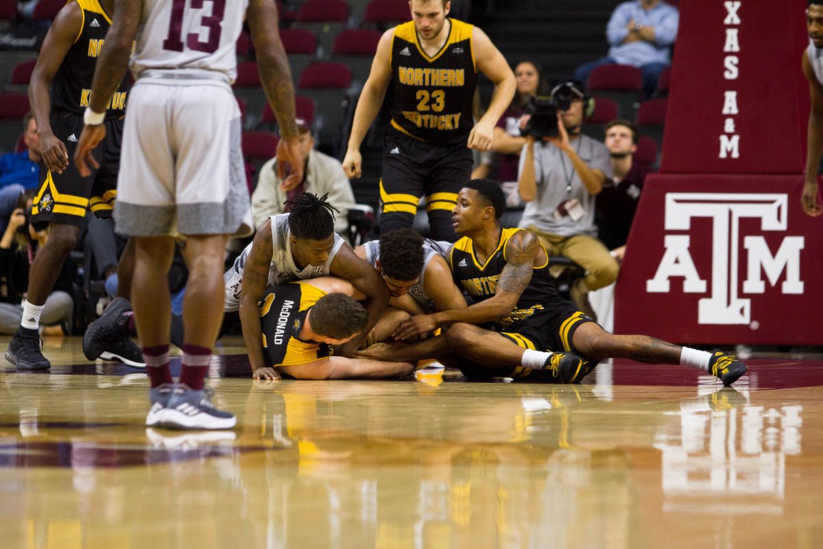 Players from both teams pile on top of each other in an effort to gain possession of the ball.