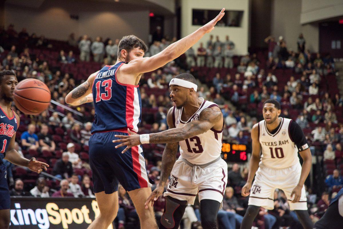 Guard Duane Wilson throws the ball around Ole Miss's center, Dominik Olejniczak.