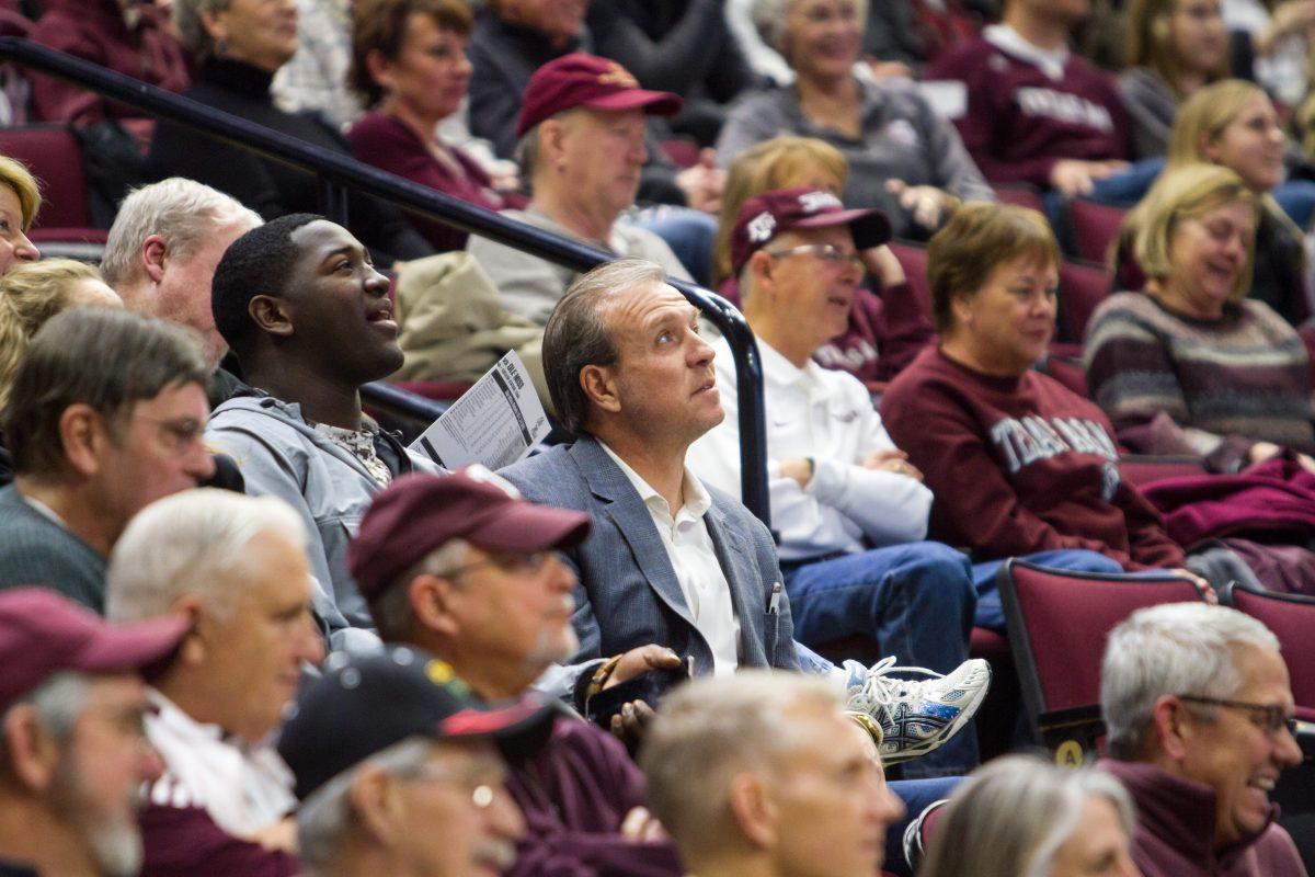 <p>Texas A&M head football coach Jimbo Fisher sits with Boling High School recruit Vernon Jackson at the A&M basketball game. </p>