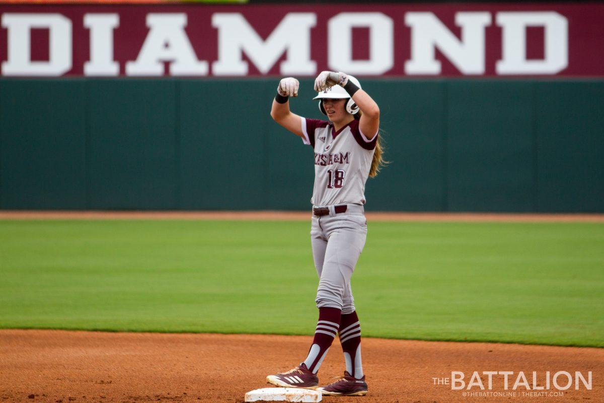 Sophomore+Sarah+Hudek+makes+a+money+sign+to+her+teammates+in+the+dugout+after+hitting+a+double.%26%23160%3B