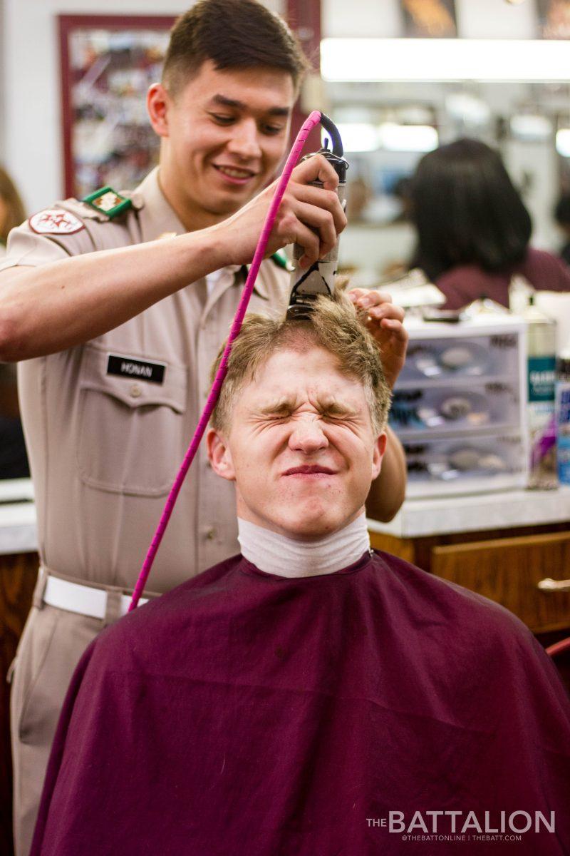 Kylar Honan, agricultural economics junior and Company E-2 first sergeant, begins buzzing the hair of Blinn Team freshman Kyle Simcox, also known as &#8220;fish Simcox.&#8221;