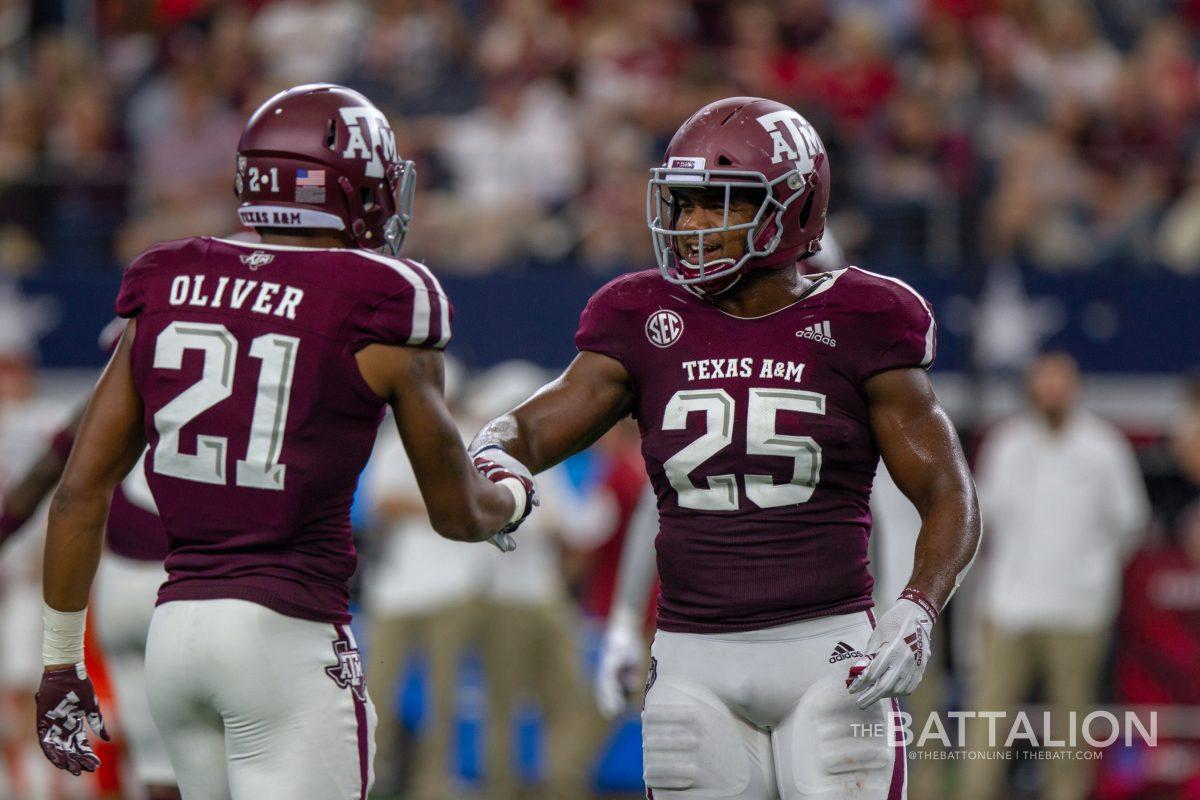 Junior defensive back Charles Oliver and junior linebacker Tyrel Dodson shake hands in between plays.