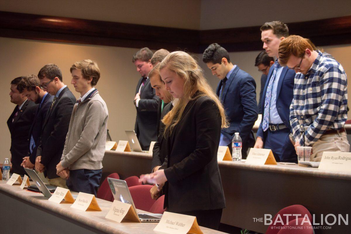 Senators pray at the beginning of the meeting.