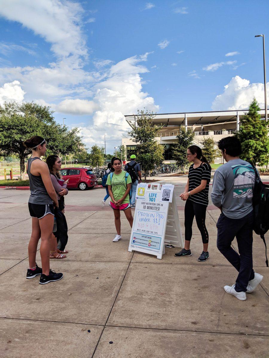 LIFE 101 volunteers Janet Gaytan, Class of 2018, and Mallory Bobzien, Class of 2019, talk to students on campus about affordable protein options.