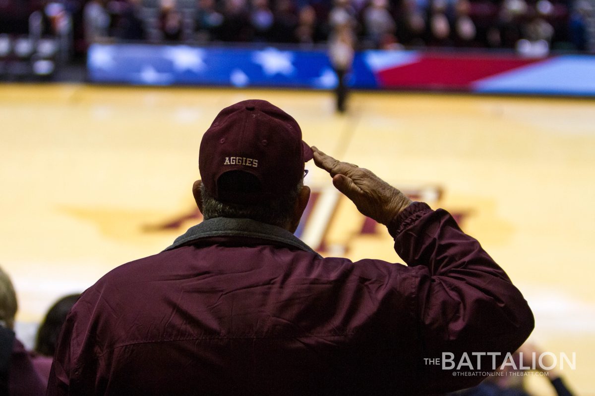 An Aggie salutes during the singing of the national anthem.