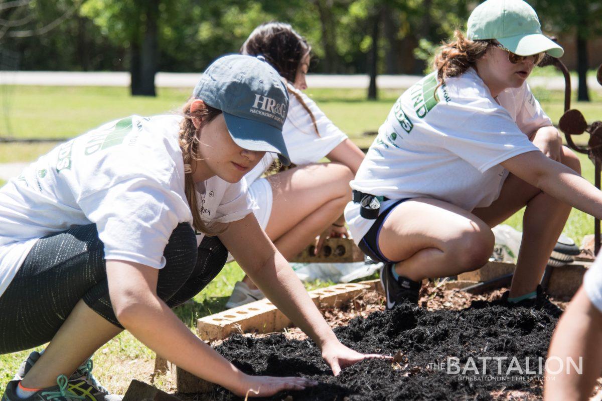 Then-sophomores Meagan Banowsky and Danielle Alford work in flower beds during The Big Event in 2017.