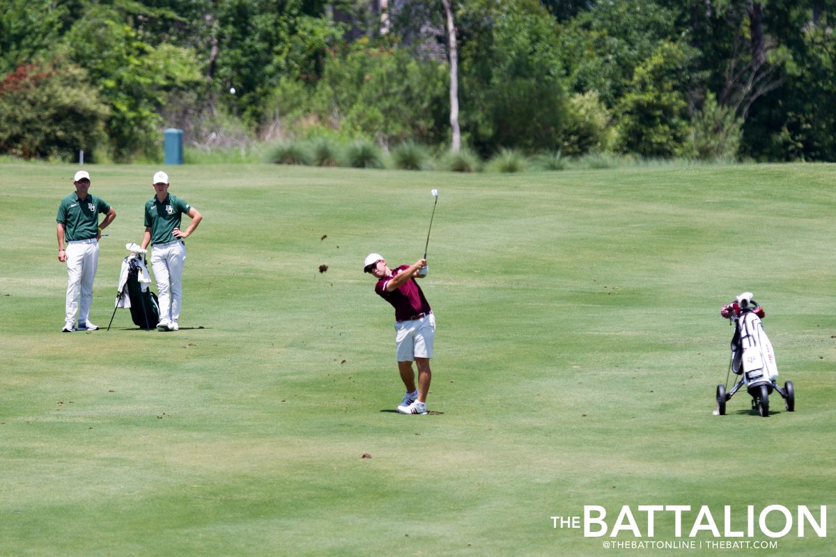 Senior+Andrew+Paysse+takes+his+shot+at+the+green+from+the+fairway.