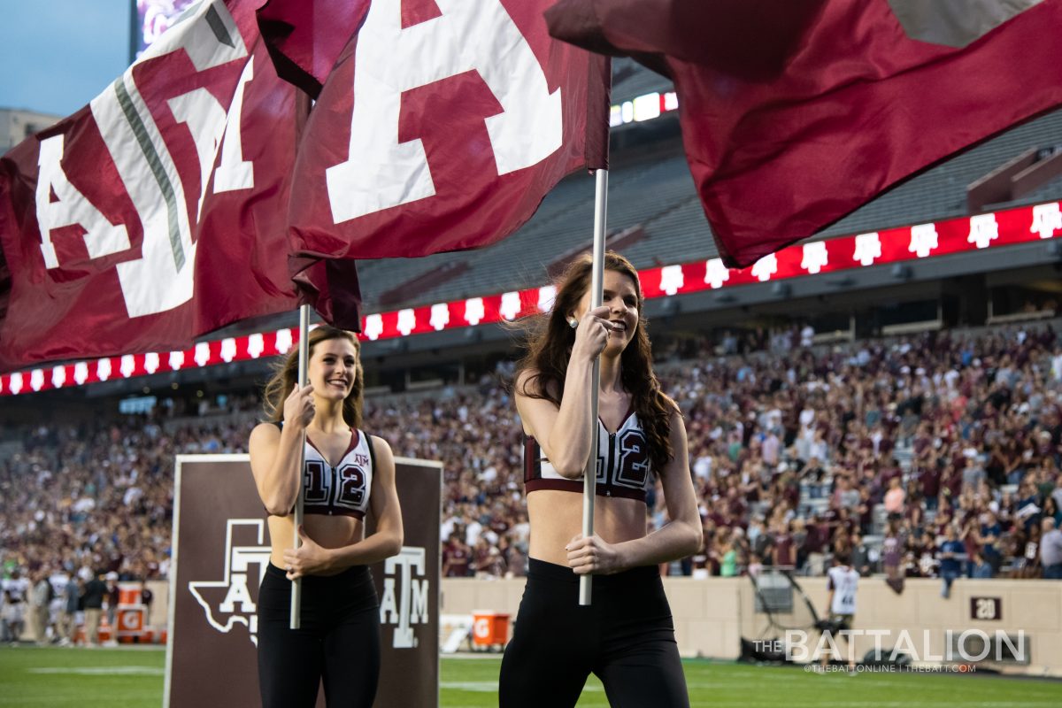 Members of the Aggie dance team carry flags off of the field before the Maroon and White football game on April 12 at Kyle Field.