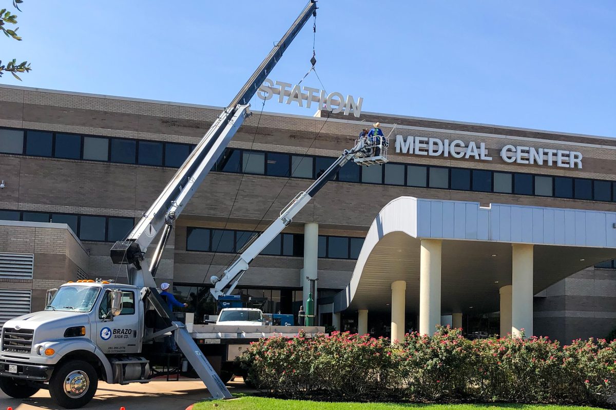 Crews replace the sign of&#160;College Station Medical Center as it becomes College Station Hospital after being acquired by CHI St. Joseph Health.