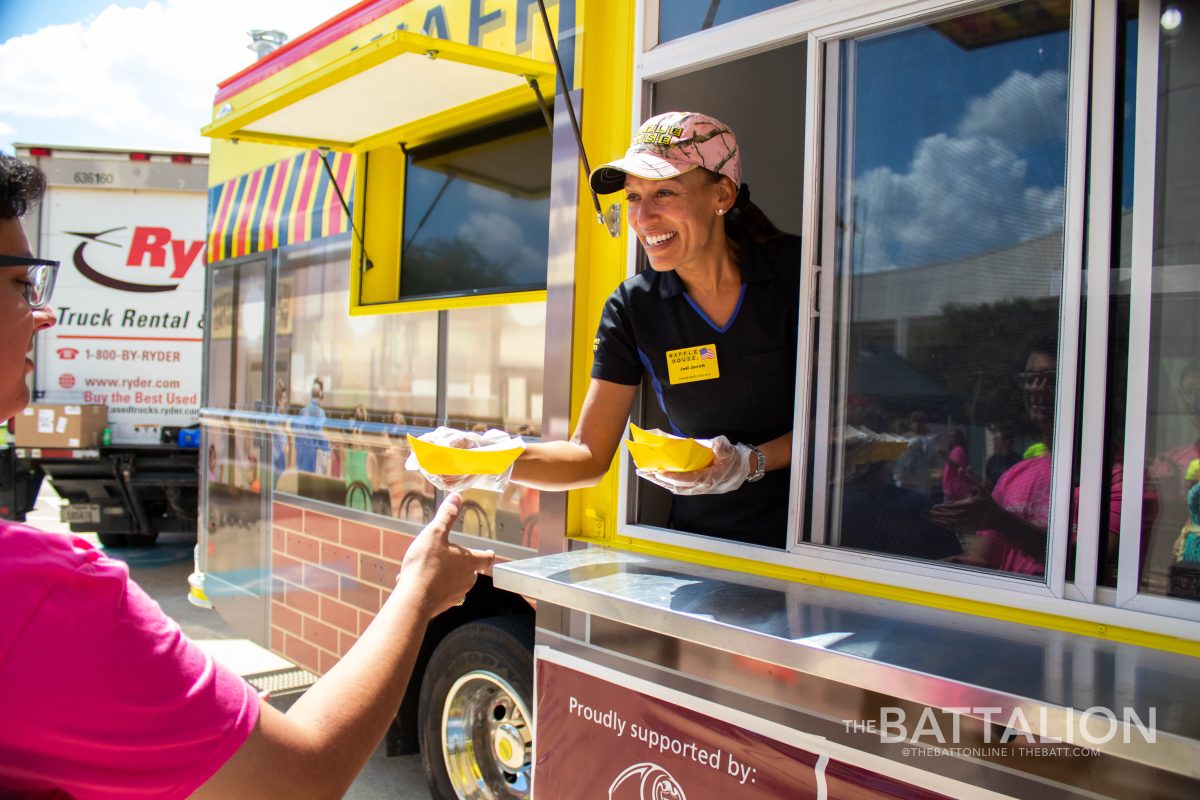 Waffle House team member Jodi Jarrett hands out free waffles and hashbrowns to students during the Waffle House food truck&#8217;s stop in College Station for National Waffle Week.