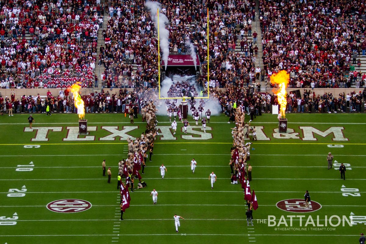 The yell leaders lead the A&M football team out of the tunnel.