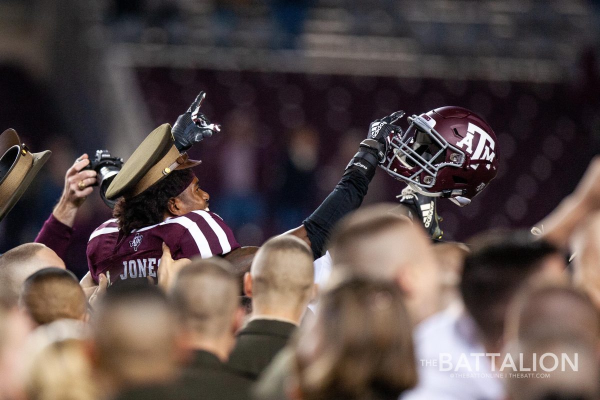 Defensive back Myles Jones is carried by freshman cadets along with the yell leaders after the Aggie victory.