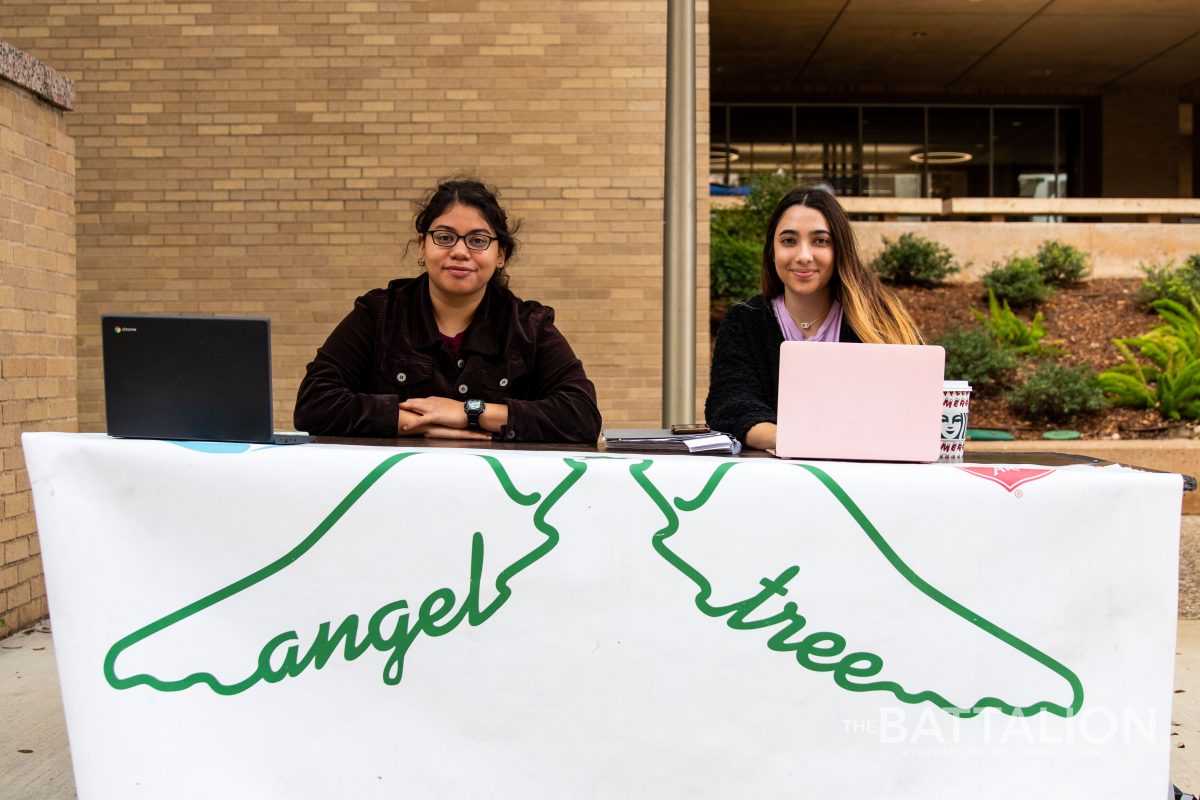Members of MSC ALOT Megan Zogaib and Carolina Vazquez work an Angel Tree table outside of Evans Library.