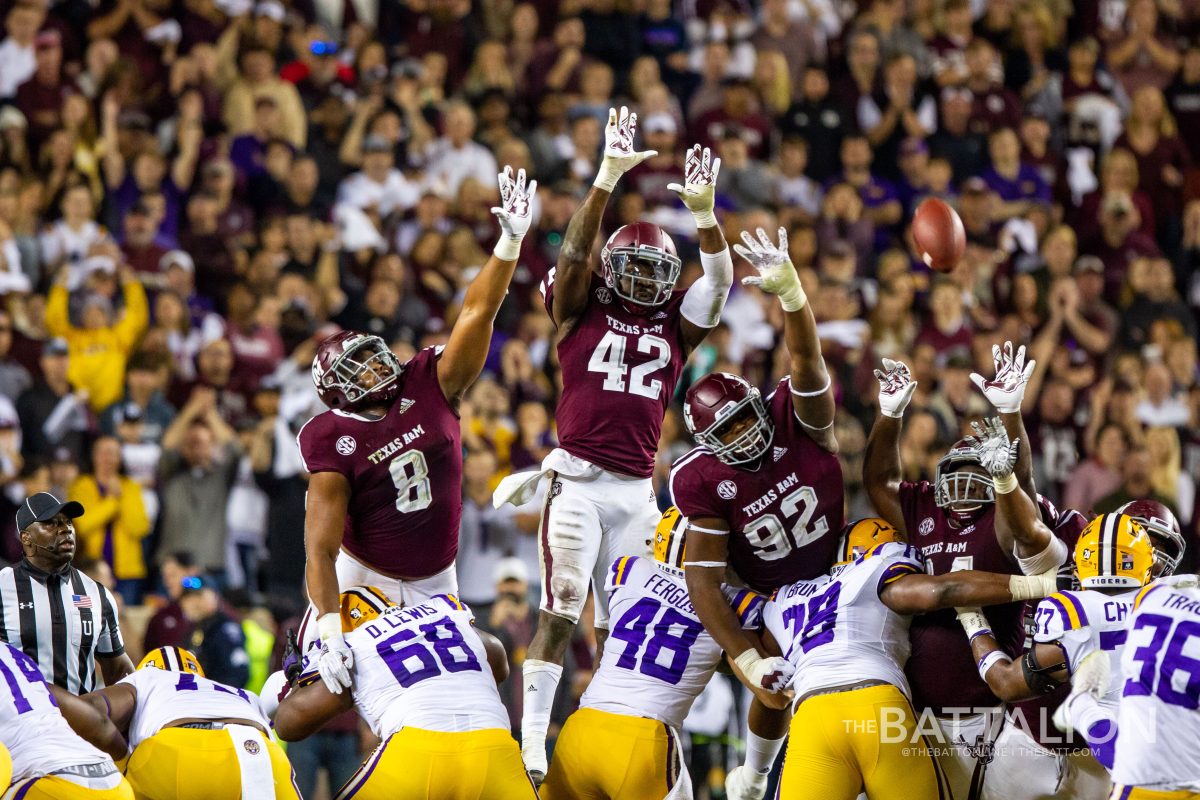 The Aggie defense reaches in an attempt to block an LSU kick during the 2018 Thanksgiving game in Kyle Field.