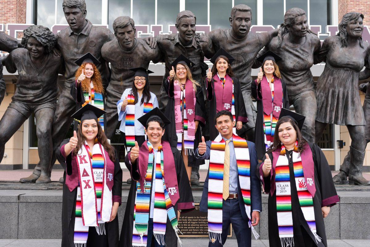 Latinx Graduation Ceremony founders pose in front of the War Hymn monument. 