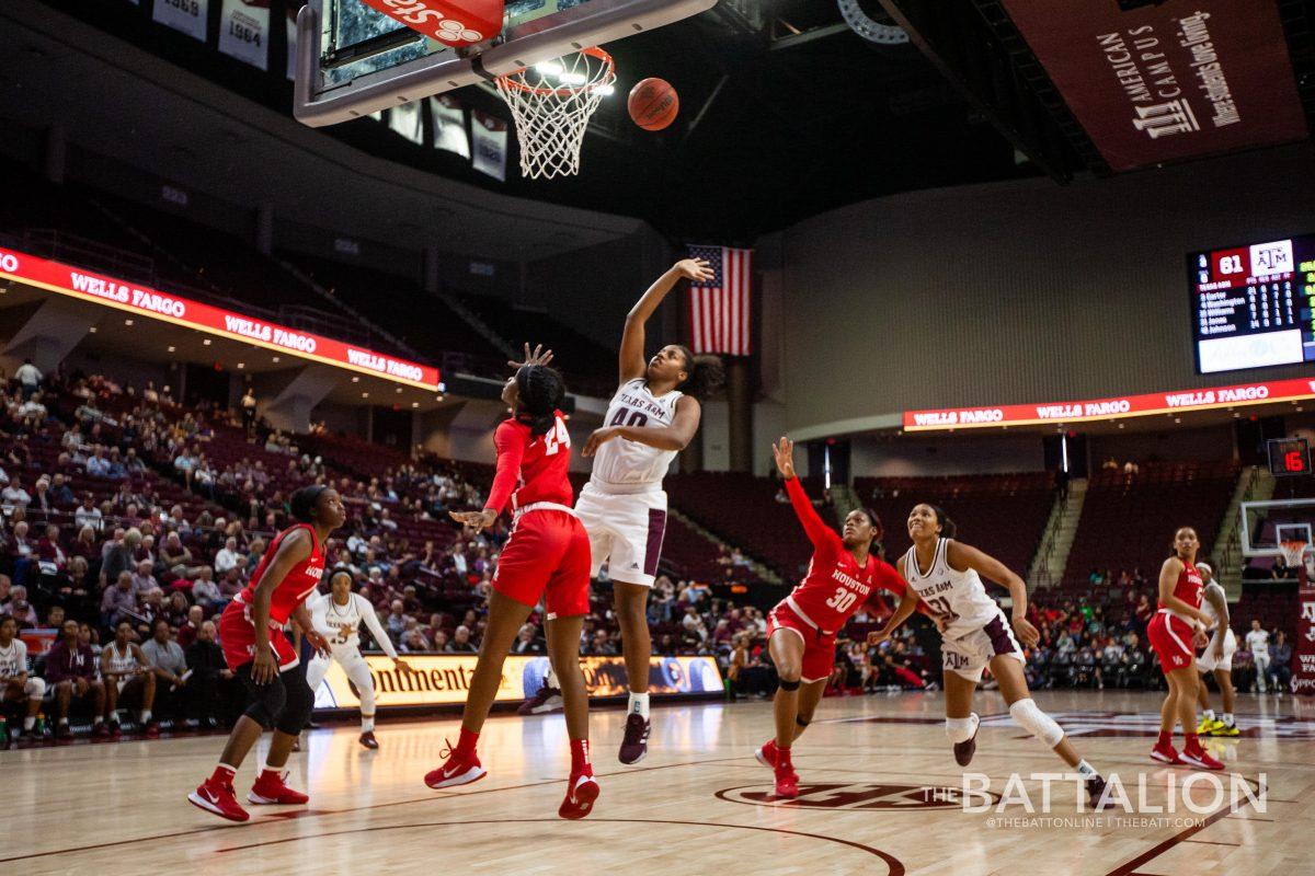 Center Ciera Johnson leaps over Houston defenders for the shot.