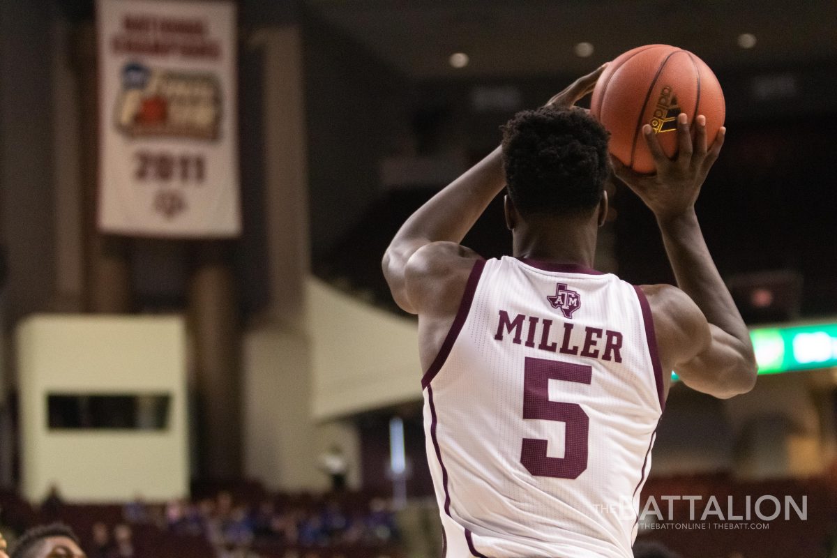 Freshman Forward Emanuel Miller holds the ball high in the air as he looks for a teammate to pass it to.