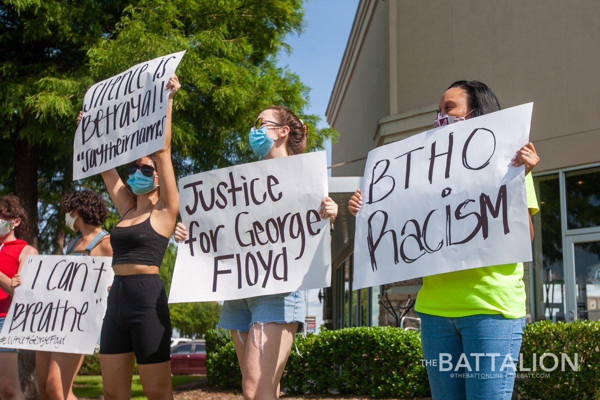 A group of around 20 people held signs at the intersection of Texas Ave. and George Bush Drive in protest of the fatal arrest of George Floyd and the killing of unarmed black men.