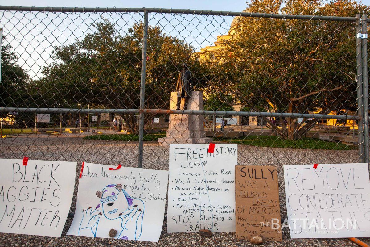 Students+placed+signs+against+the+fence+that+surround+the+statue+of+Lawrence+Sullivan+Ross.+The+fence+was+erected+following+an+incident+when+the+statue+was+vandalized+in+June+2020.