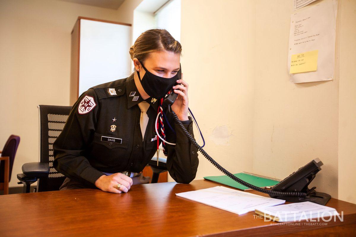 Corps Operations Officer Gracie Davis answers the guardroom phone, following the cadet escort script.