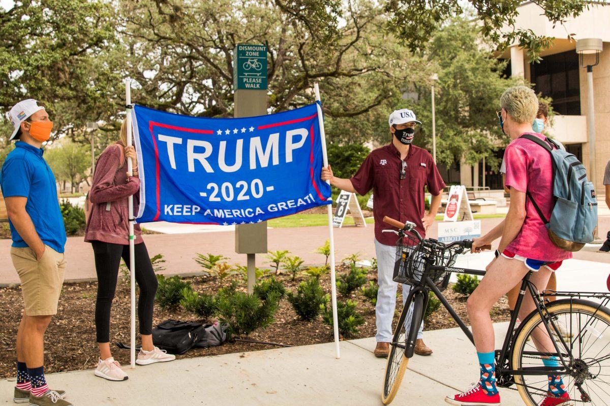 Members of the student organization Aggies for Trump banner-hold outside of the MSC.