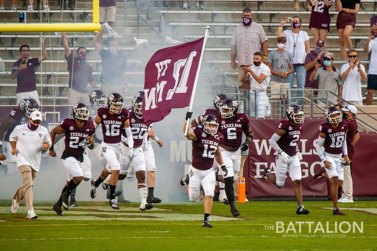 Linebacker and 2020 12th Man Braden White leads the football team onto the field.