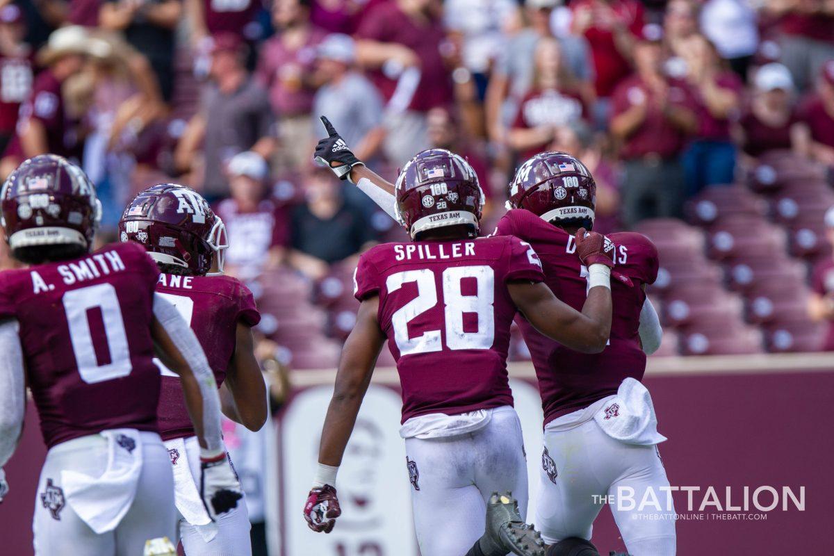 Ainias Smith, Chase Lane and Isaiah Spiller celebrate with Demond Demas after his touchdown.