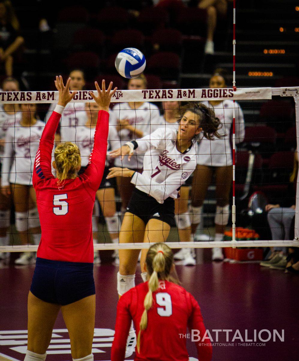 Junior outside hitter Lauren Davis spikes the ball, securing a point for the Aggies. 