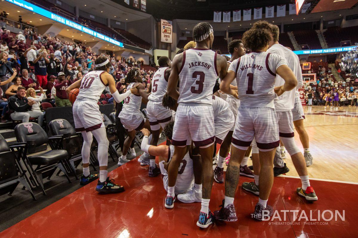 The Aggie mens basketball team celebrating on the court after a dramatic win early in their season.