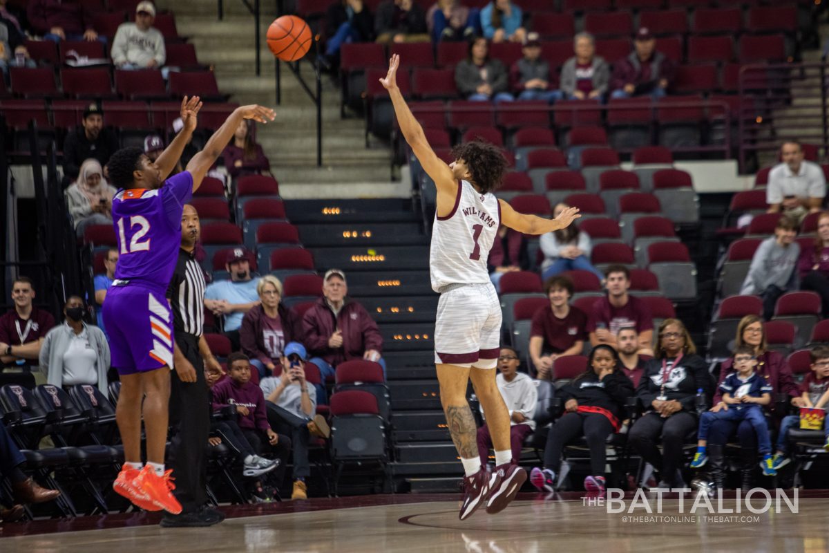Freshman guard Carvell Teasett (12) shoots a three-pointer on sophomore guard Caleb Williams (1) during the Aggies game against the Northwestern State Demons in Reed Arena on Tuesday, Dec.. 21, 2021.