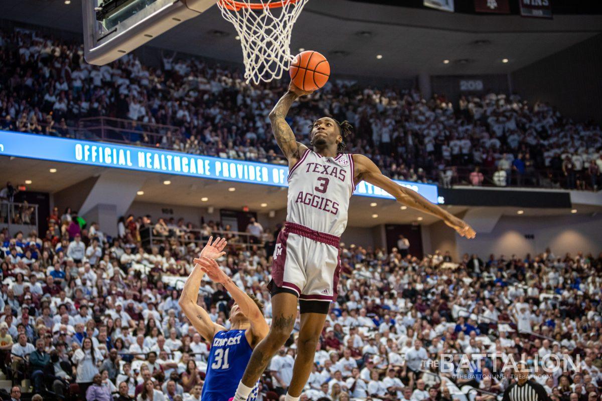 Fifth year guard Quenton Jackson (3) jumps to dunk on the Kentucky basket in Reed Arena on Wednesday Jan. 19, 2022.