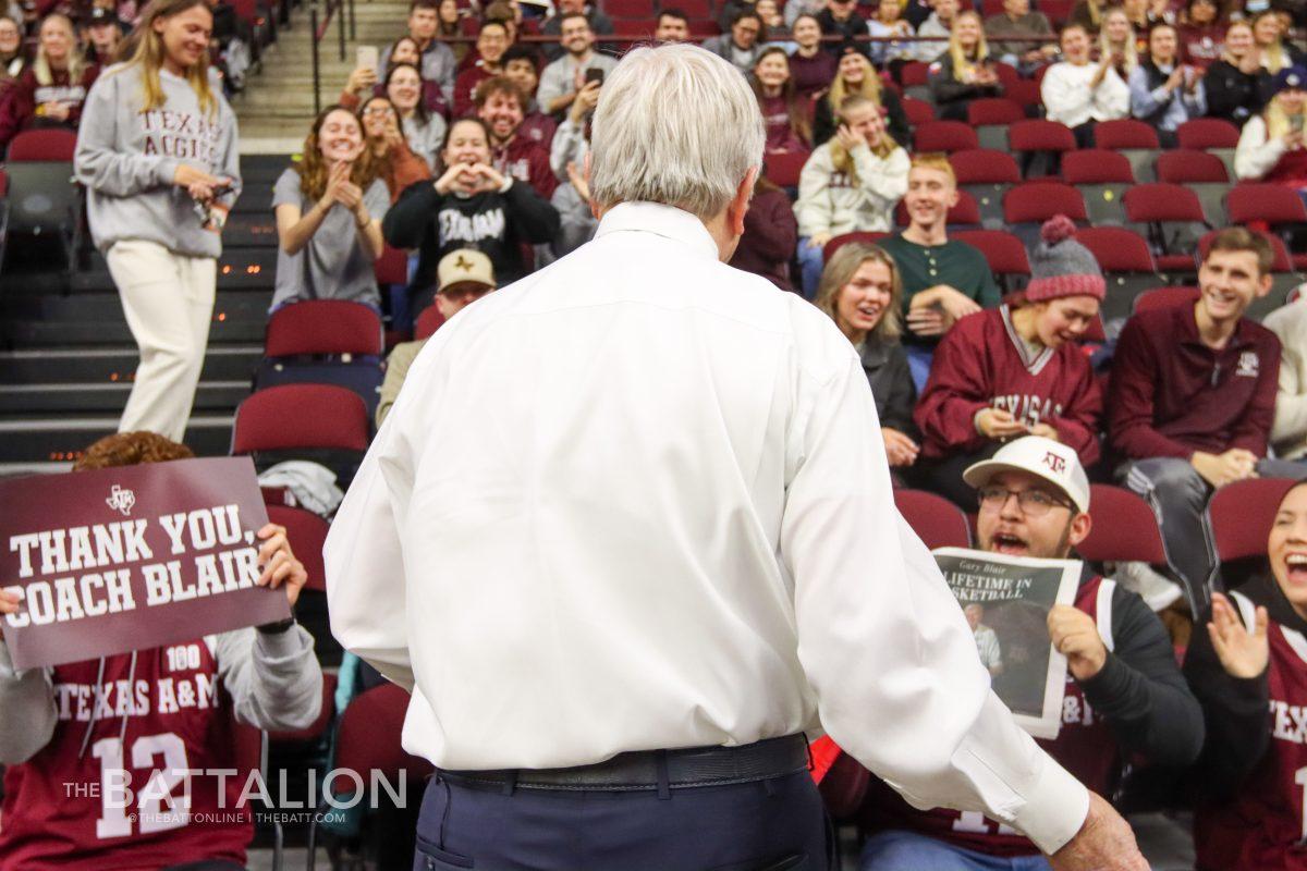 Students hold up copies of The Eagle and Thank You, Coach Blair signs, as Coach Blair passes out candy in Reed Arena on Thursday, Feb. 24, 2022.